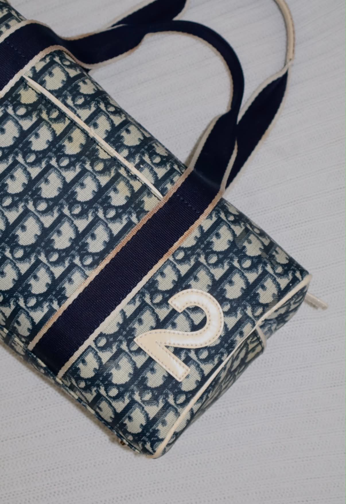 Vintage Dior Oblique canvas tote with navy webbing straps and a cream leather number two